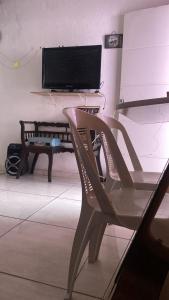 a chair in a living room with a flat screen tv at Hostel Namastê in Maceió
