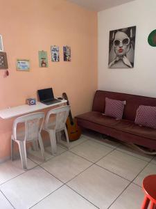 a living room with a couch and a table with a laptop at Hostel Namastê in Maceió