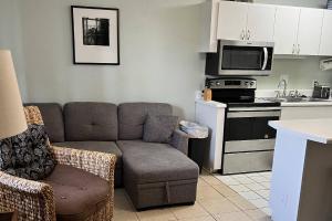 a living room with a couch and a kitchen at Tropical Isle #112 in Fort Walton Beach