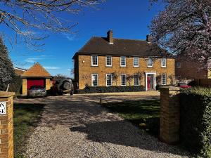 an old brick house with a red door at The Potting Cottage in Tydd Saint Giles