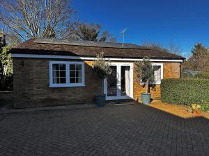 a small brick house with a white door at The Potting Cottage in Tydd Saint Giles