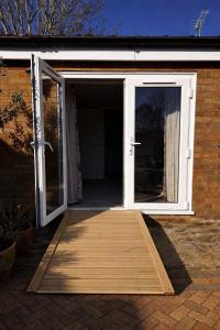 an open door with a wooden mat in front of it at The Potting Cottage in Tydd Saint Giles