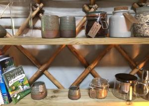a shelf with jars and other items on it at Esk Yurt in Drummelzier