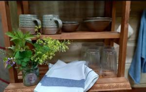a shelf with bowls and glasses and a vase with flowers at Esk Yurt in Drummelzier +27 photos