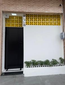 a black door on a brick building with plants at Flat jk 04 térreo in Juazeiro do Norte