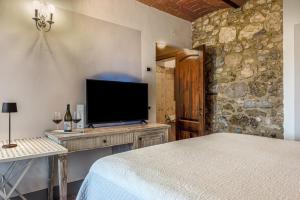 a bedroom with a bed and a flat screen tv at Villa Del Sole in San Gimignano