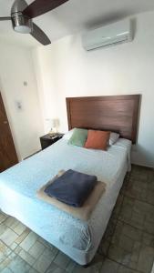 a bedroom with a bed with a blue blanket on it at El Cedralito in Mérida