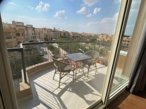 a balcony with a table and chairs on a balcony at Maison 7 Residence in Obour