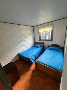 a bedroom with two beds and a window at Cabañas costa rio imperial in Quillén