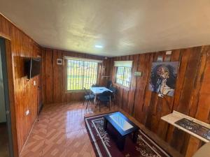 a room with wooden walls and a table in a room at Cabañas costa rio imperial in Quillén
