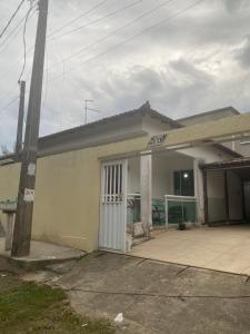 a small house with a porch and a garage at Casa dá Jo in Rio das Ostras