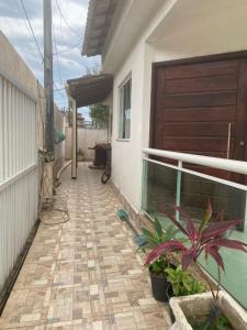 a walkway outside of a house with a door and plants at Casa dá Jo in Rio das Ostras