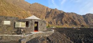 a small building on a mountain with mountains in the background at Funco Jacó in Portela