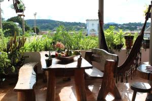 a table with chairs and a bowl of fruit on a balcony at Pousada Torre dos Mouros in Pirenópolis