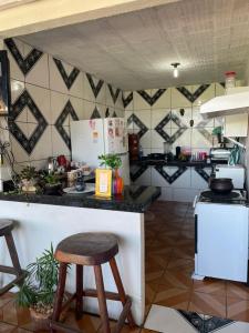 a kitchen with a counter with stools in it at Pousada Torre dos Mouros in Pirenópolis