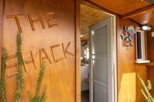 a sign on the wall of a house that reads the rental at The Shack in Mangonui