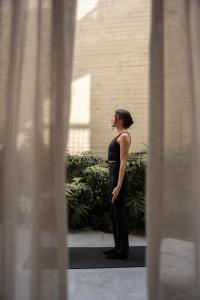 a woman in a black dress looking out a window at Casa Cibeles by Lumina in Mexico City +42 photos