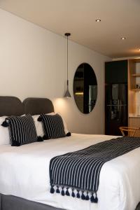 a bedroom with a large bed with black and white pillows at Casa Cibeles by Lumina in Mexico City