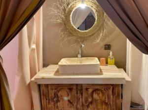 a bathroom with a sink and a mirror at Merzouga Retreat Camp in Merzouga