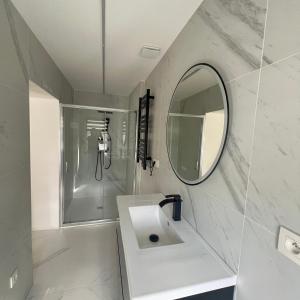 a white bathroom with a sink and a mirror at Le onze in Namur