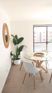 a white room with a table and chairs and a plant at Shoal Bay Water Views, 1 night stays available in Nelson Bay