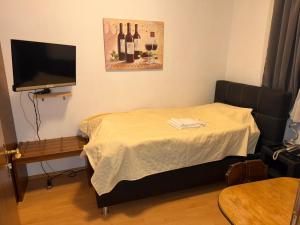 a room with a bed with a television and wine bottles at Hotel Zunftstube in Saarburg