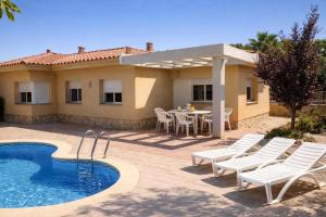 a villa with a swimming pool and a table and chairs at Casa Sastre - "Pet Friendly - Piscina Privada - Playa - BBQ - Parking - Delta de l'Ebre - Riumar" in Riumar