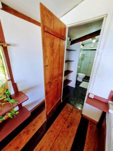 a room with a wooden door and a bathroom at MistiHouse Surf & Amor con vista al mar a 50 mts de la playa in Itacaré