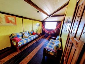 a living room with a couch and a window at MistiHouse Surf & Amor con vista al mar a 50 mts de la playa in Itacaré +9 photos