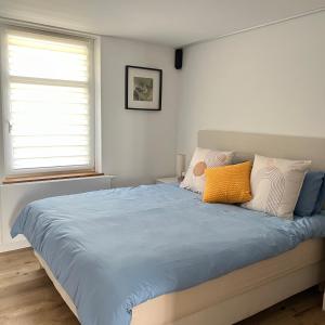a bedroom with a bed with blue sheets and pillows at Le onze in Namur