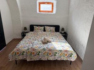 a bed with a blanket and two shoes on it at La Casa de Nido-Cozy Studio in Veszprémfajsz