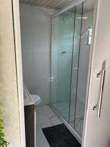 a glass shower in a bathroom with a toilet at Condomínio Central Sobradinho in Uruguaiana