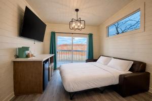a bedroom with a bed and a table and a window at Ultra Luxury Tiny Home with Deck in Page