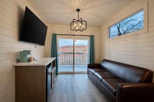 a living room with a leather couch and a balcony at Ultra Luxury Tiny Home with Deck in Page