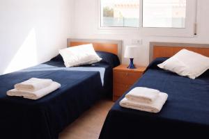two beds sitting next to each other in a bedroom at Casa Mañet - "Pet Friendly - Piscina Privada - Playa - BBQ - Parking - Delta de l'Ebre - Riumar" in Riumar +13 photos