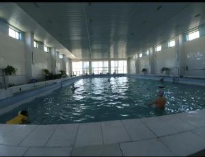 a large swimming pool with people in the water at Ak-Kalpak in Cholpon-Ata