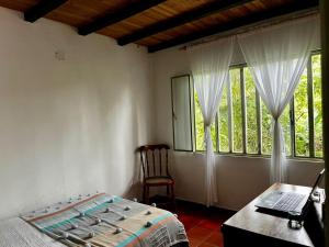 a bedroom with a bed and a desk and a window at Tu Refugio en el Campo in San Francisco