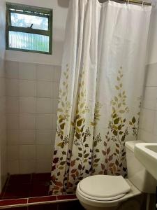 a bathroom with a toilet and a shower curtain at Tu Refugio en el Campo in San Francisco