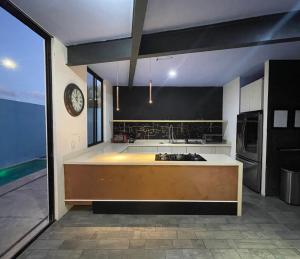 a kitchen with a counter top and a clock on the wall at Casa Gigante de lujo, con piscina privada, 4 amplias habitaciones con baño privado in Playa del Carmen