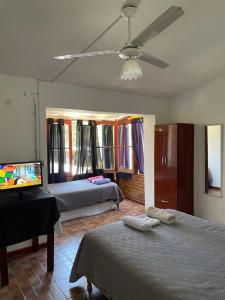a bedroom with two beds and a ceiling fan at CASONA Malva del Rio in Villa Carlos Paz