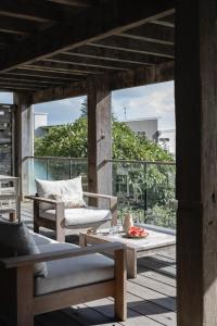 a patio with a couch and a table on a deck at Bay Properties Bridgewood in Yamba