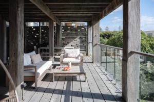 a wooden porch with a couch and a table at Bay Properties Bridgewood in Yamba