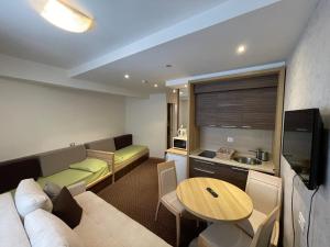 a living room with a couch and a table at Apartments Konaci BOOKING in Kopaonik