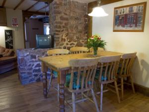 a wooden table with chairs and a vase of flowers on it at Stables- Ukc4912 in Timberscombe