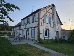 a large white building with a table in front of it at La Hacienda Verde in Heudreville-sur-Eure