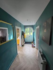 a room with blue walls and a hallway with a bedroom at La Hacienda Verde in Heudreville-sur-Eure