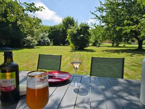 a table with a bottle of wine and a glass at La Hacienda Verde in Heudreville-sur-Eure