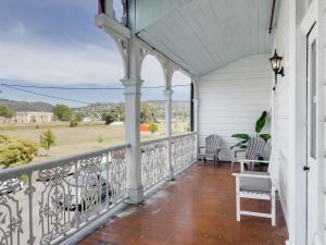 a balcony with chairs and a view of a field at The Fenway Hostel in Launceston