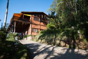 a large brick building with a path in front of it at Spa e Hotel Fazenda Gaura Mandir in Teresópolis