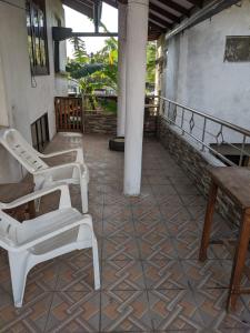 two white chairs and a table on a patio at Stay in flying in Katunayaka